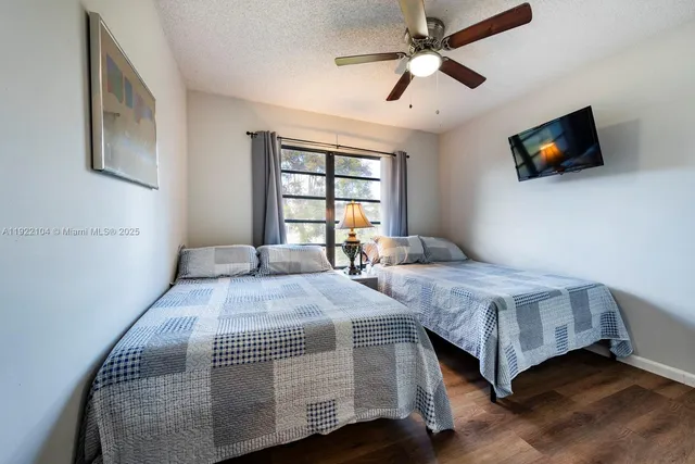 a spacious bedroom with a bed and a flat screen tv
