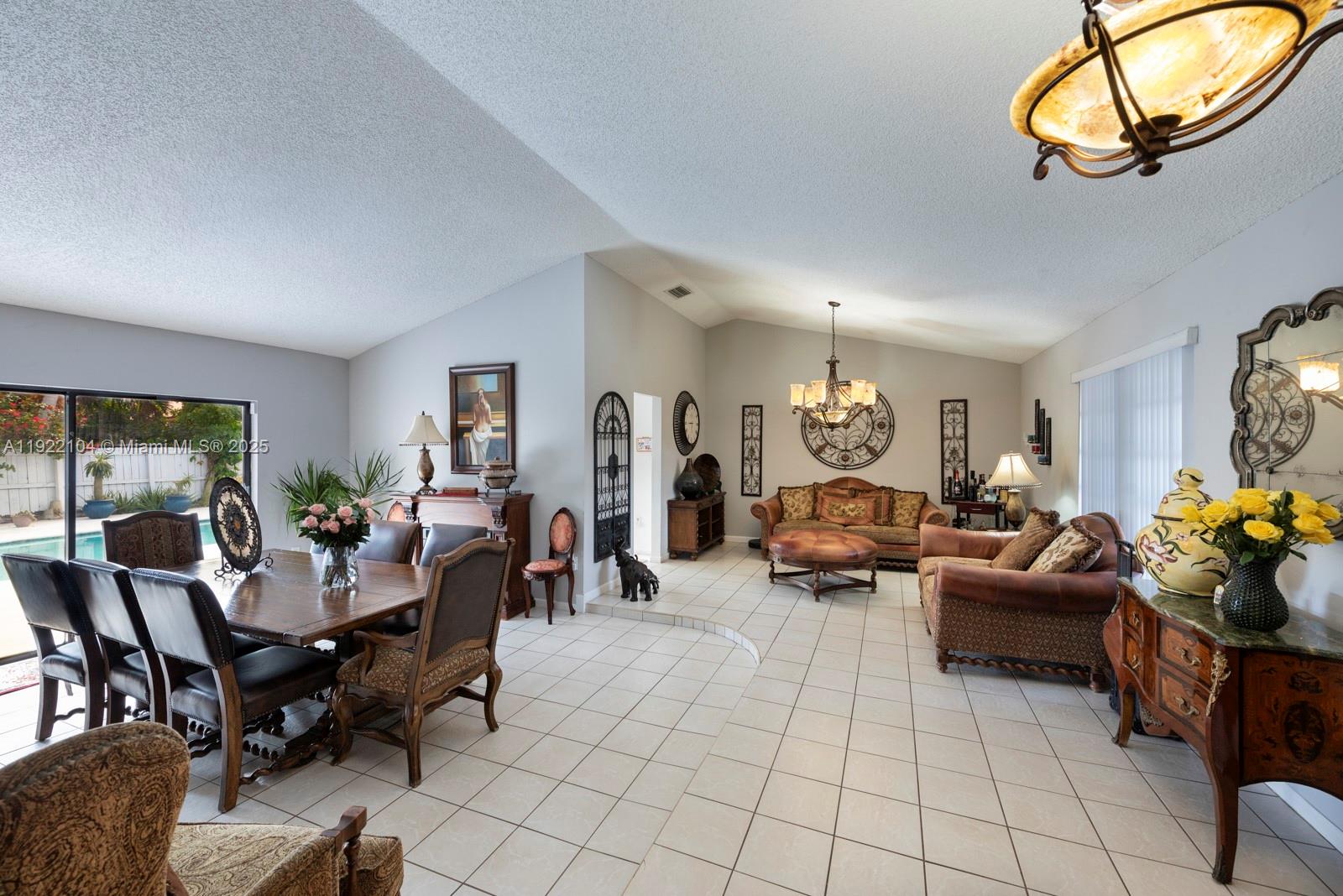 11724 Southwest 95th Street Miami, FL 33186 - Photo 4 of 25 a living room with furniture a chandelier and a large window