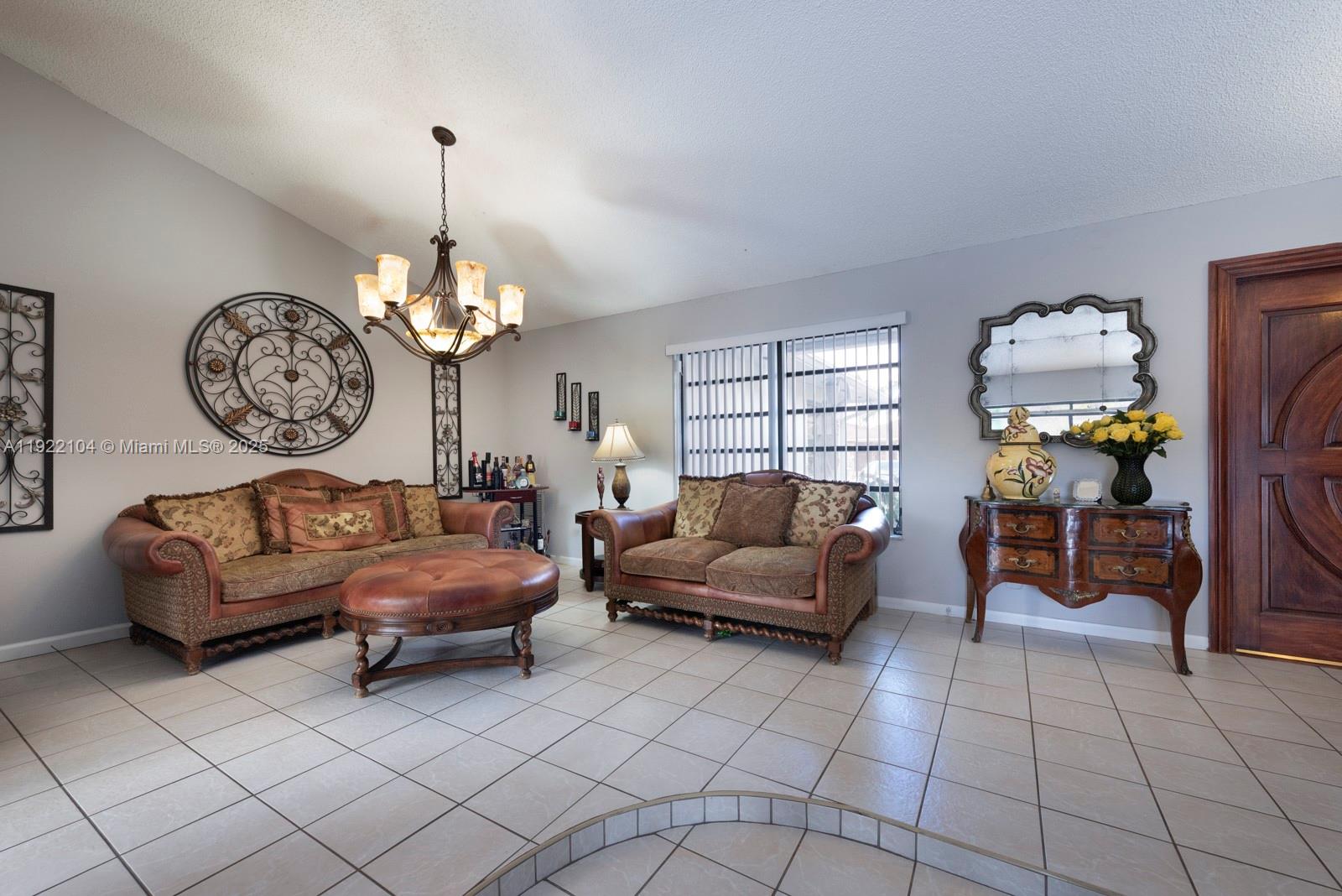 11724 Southwest 95th Street Miami, FL 33186 - Photo 5 of 25 a living room with furniture a chandelier and a mirror