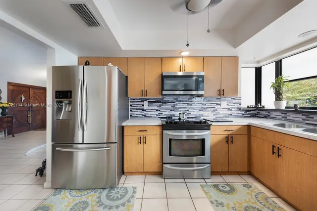 a kitchen with stainless steel appliances granite countertop a stove a refrigerator and a sink