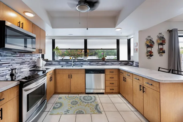 a kitchen with stainless steel appliances granite countertop a sink stove and cabinets