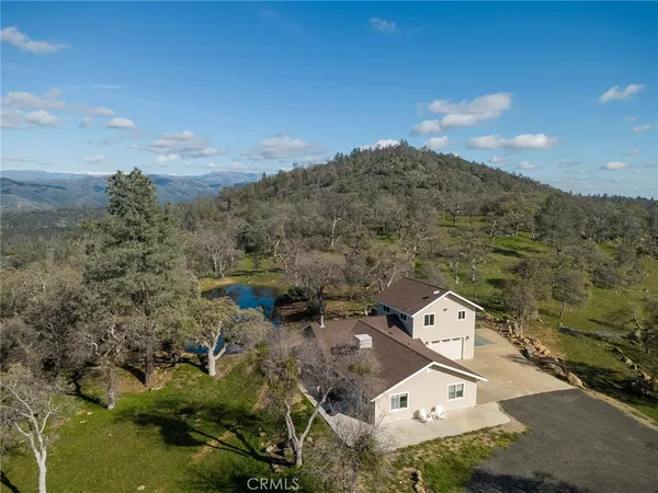 an aerial view of a house with a mountain