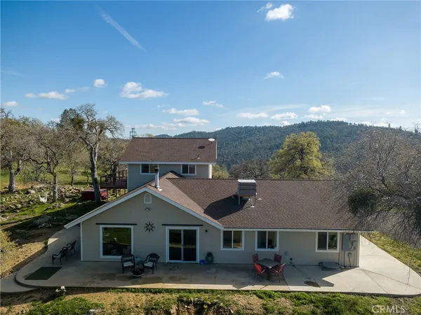 an aerial view of house with yard and mountain view in back