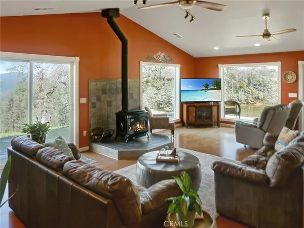 a living room with furniture a fireplace and a floor to ceiling window