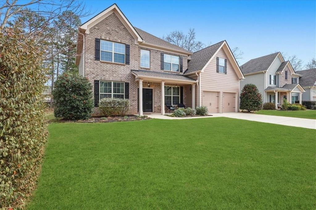 525 Widgeon Way Jefferson, GA 30549 - Photo 2 of 65 a front view of a house with a garden and trees