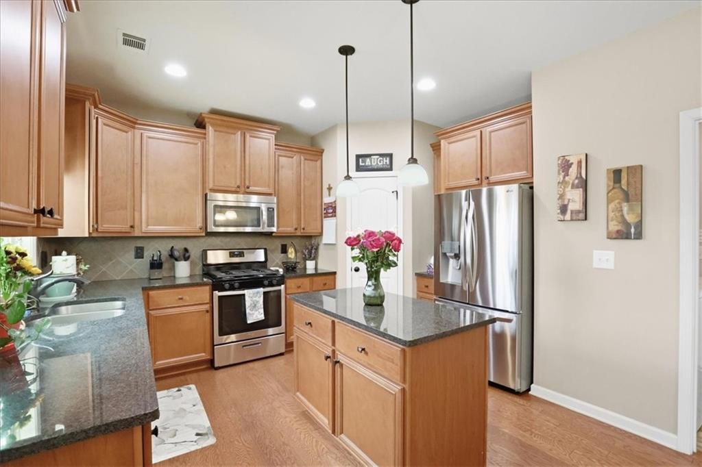 525 Widgeon Way Jefferson, GA 30549 - Photo 22 of 65 a kitchen with stainless steel appliances granite countertop a refrigerator a sink dishwasher a stove and white cabinets with wooden floor