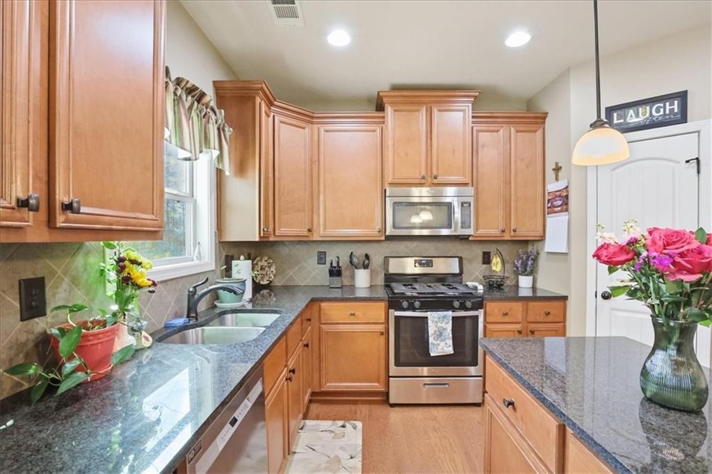 525 Widgeon Way Jefferson, GA 30549 - Photo 23 of 65 a kitchen with stainless steel appliances granite countertop a sink stove and cabinets