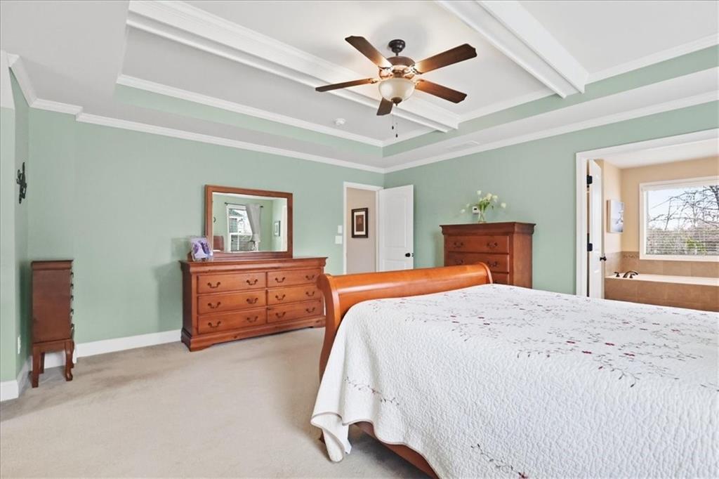 525 Widgeon Way Jefferson, GA 30549 - Photo 44 of 65 a bedroom with a large bed and a chandelier