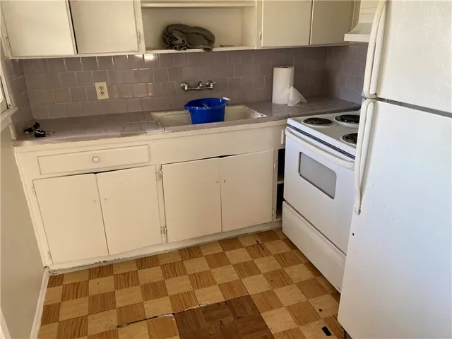 a kitchen with a stove top oven and cabinets