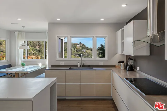 a kitchen with granite countertop a sink and white cabinets