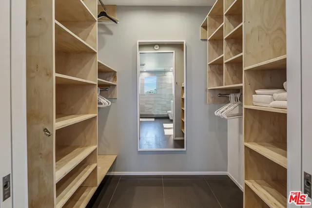 a view of walk in closet with empty racks