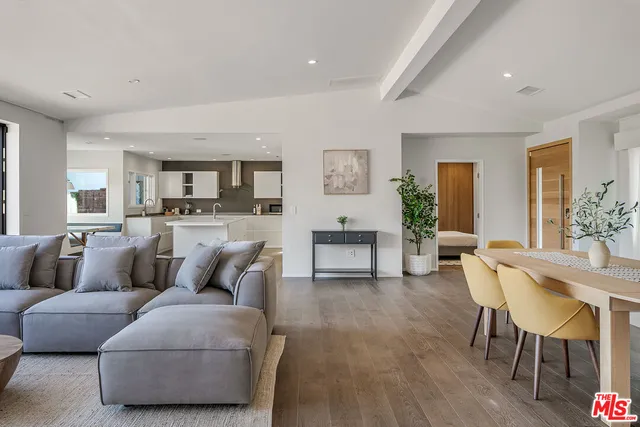 a living room with furniture and a dining table with kitchen view