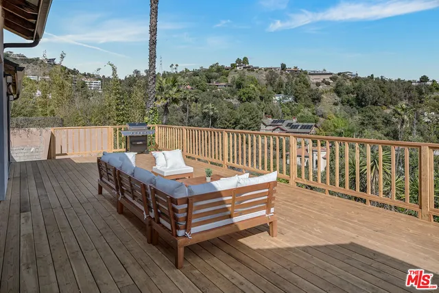 a balcony with wooden floor table and chairs