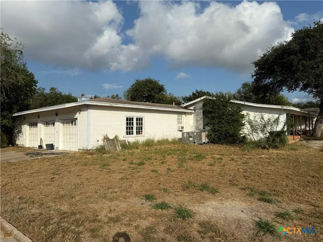 a view of house with yard and car parked
