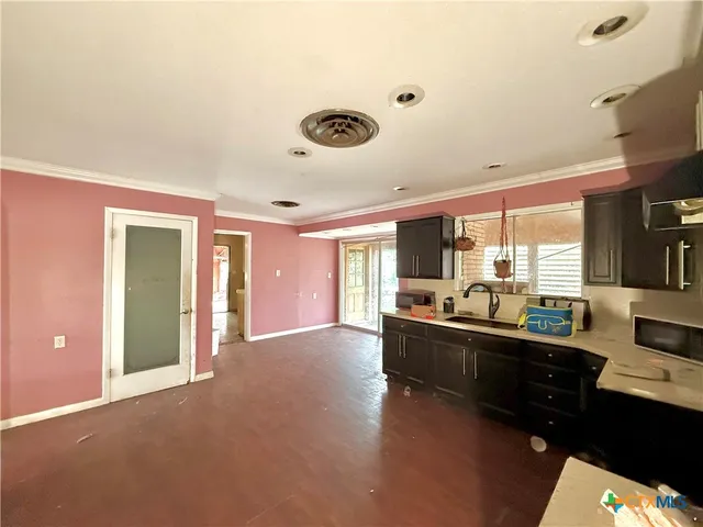 a large living room with stainless steel appliances kitchen island granite countertop a sink and cabinets