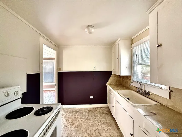 a kitchen with a sink a stove and a refrigerator