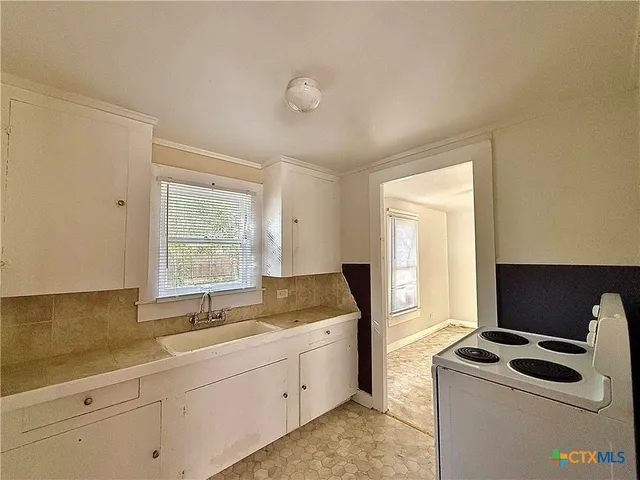 a kitchen that has a sink and a stove