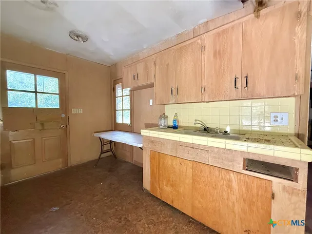 a kitchen with stainless steel appliances granite countertop a sink a stove and a refrigerator