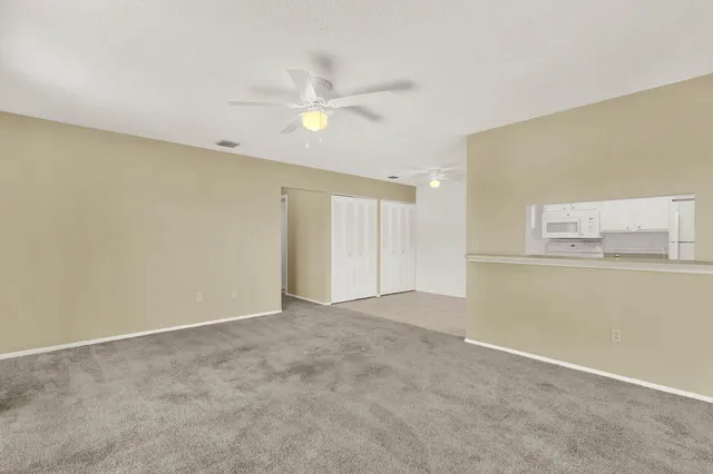 a kitchen with granite countertop white cabinets and white appliances
