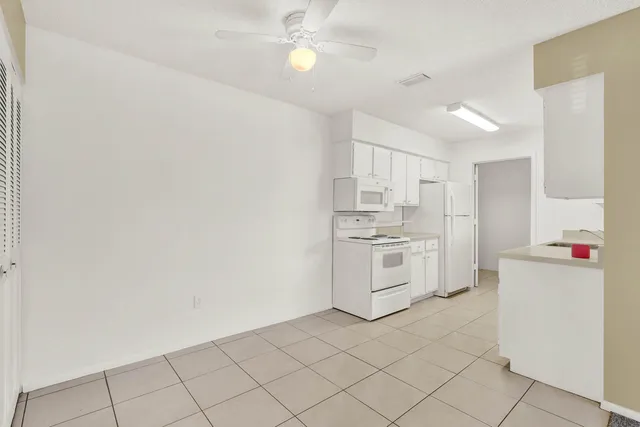 a room with a bed and a view of kitchen