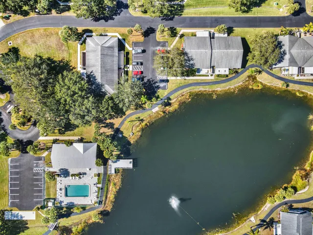 an aerial view of a house with a garden and lake view