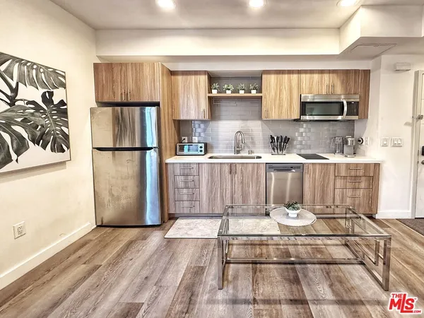 a kitchen with a refrigerator and a stove top oven