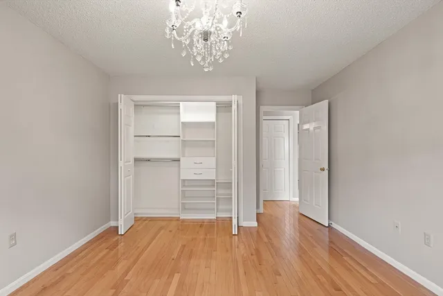 wooden floor in an empty room with a chandelier