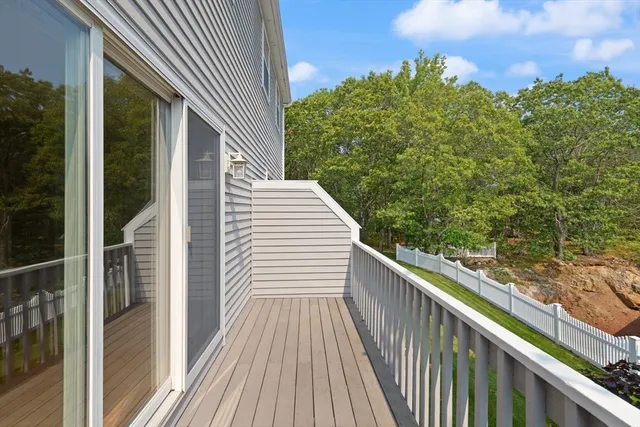 a view of a balcony with wooden floor and fence