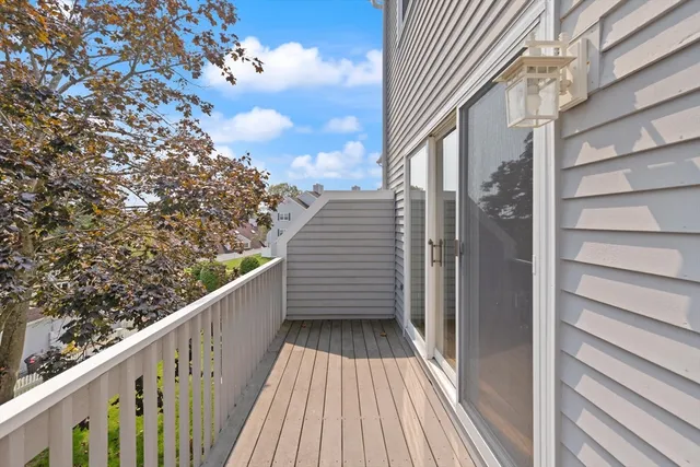 a view of a balcony with wooden floor and fence