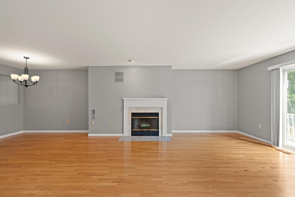 6 Countryside Lane, Unit 1303 Salem, MA 01970 - Photo 5 of 26 an empty room with wooden floor fireplace and window