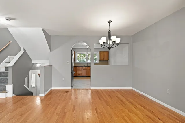 a view of a livingroom with a fireplace a chandelier and wooden floor