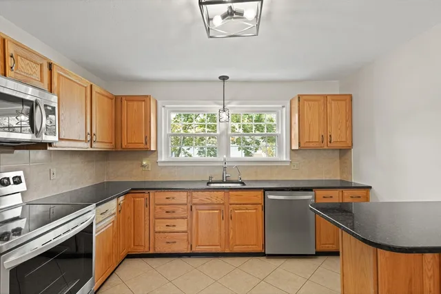 a kitchen with stainless steel appliances granite countertop a stove a sink and a microwave