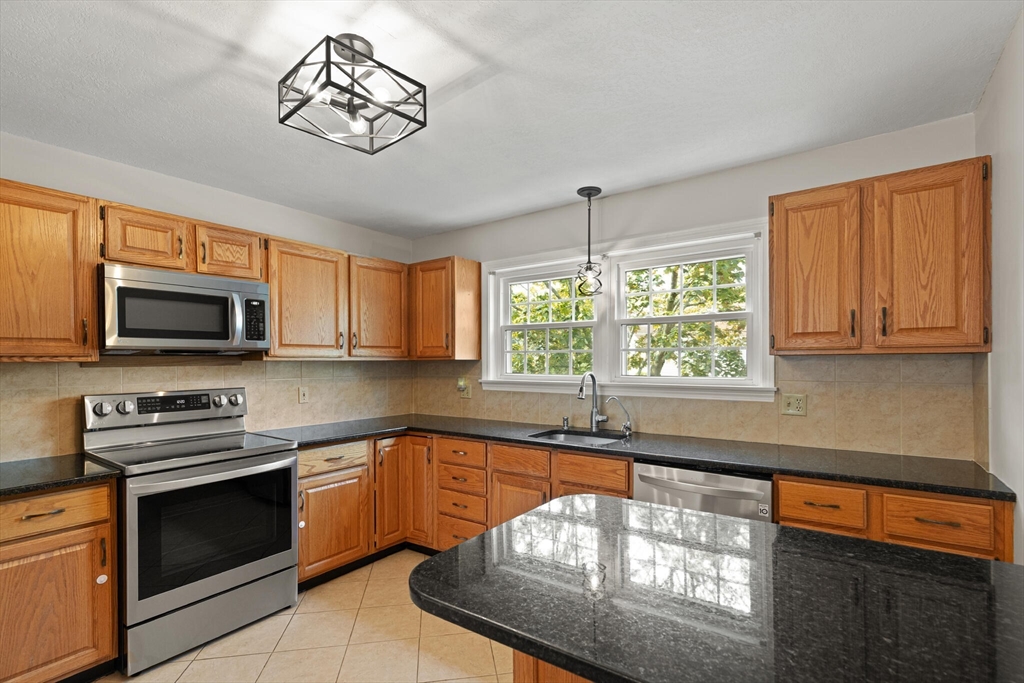 6 Countryside Lane, Unit 1303 Salem, MA 01970 - Photo 8 of 26 a kitchen with stainless steel appliances a stove sink microwave and cabinets