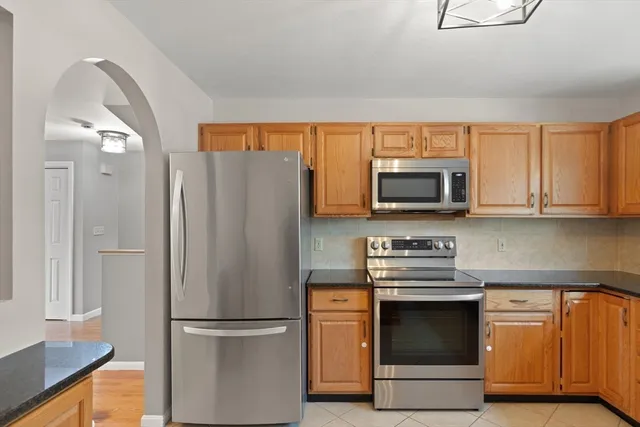 a kitchen with stainless steel appliances granite countertop a refrigerator and a stove top oven