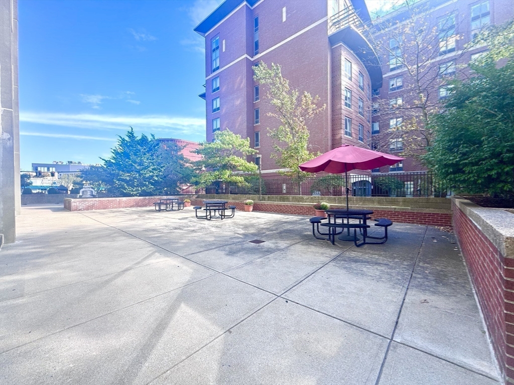 133 Park Street, Unit 703 Brookline, MA 02446 - Photo 14 of 25 an outdoor space with patio furniture and white umbrellas