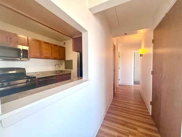 a view of a hallway with wooden floor and staircase