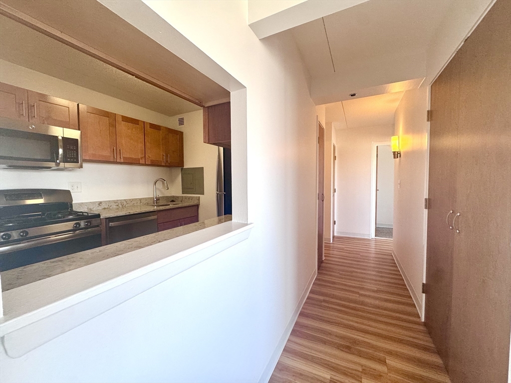 133 Park Street, Unit 703 Brookline, MA 02446 - Photo 3 of 25 a view of a hallway with wooden floor and staircase