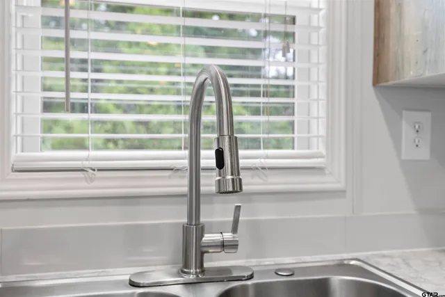 a close view of a faucet a sink and a window
