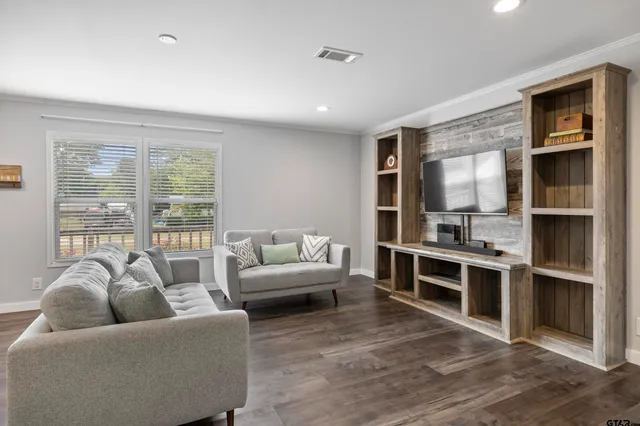 a living room with furniture windows and kitchen view