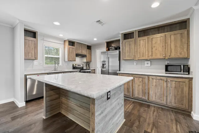a kitchen with stainless steel appliances granite countertop a sink stove and cabinets