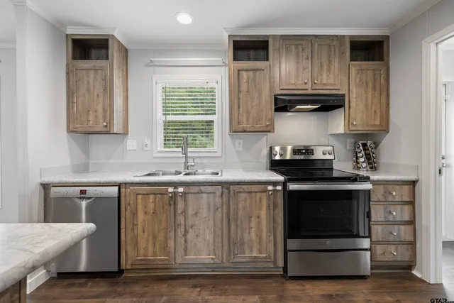 a kitchen with stainless steel appliances granite countertop a stove a sink and a microwave