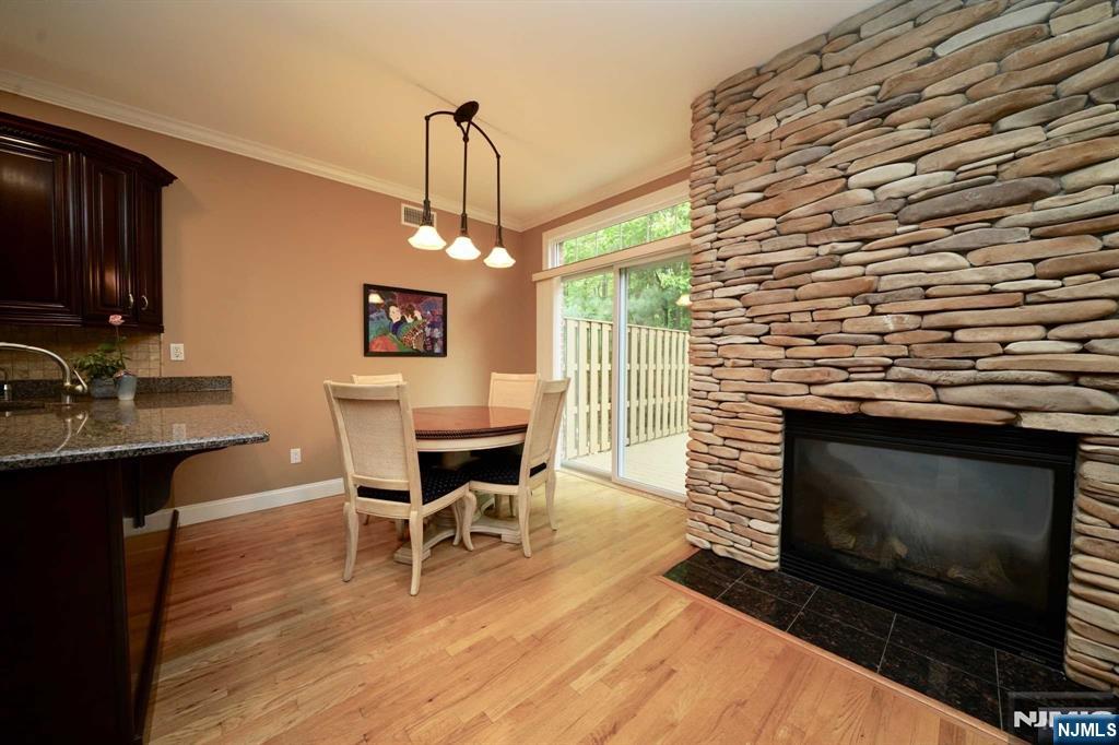 1 Candlewood Drive, Unit 1 Old Tappan, NJ 07675 - Photo 15 of 27 a dining room with a wooden floor a fireplace a rug and a chandelier