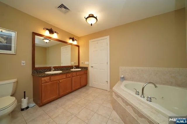 a bathroom with a granite countertop sink a toilet and bathtub