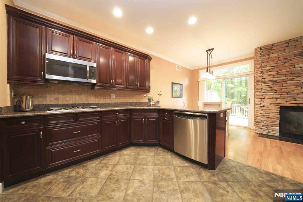 1 Candlewood Drive, Unit 1 Old Tappan, NJ 07675 - Photo 8 of 27 a kitchen with stainless steel appliances granite countertop a stove a sink and a microwave