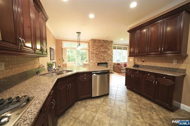 a large kitchen with granite countertop a stove a sink and a microwave