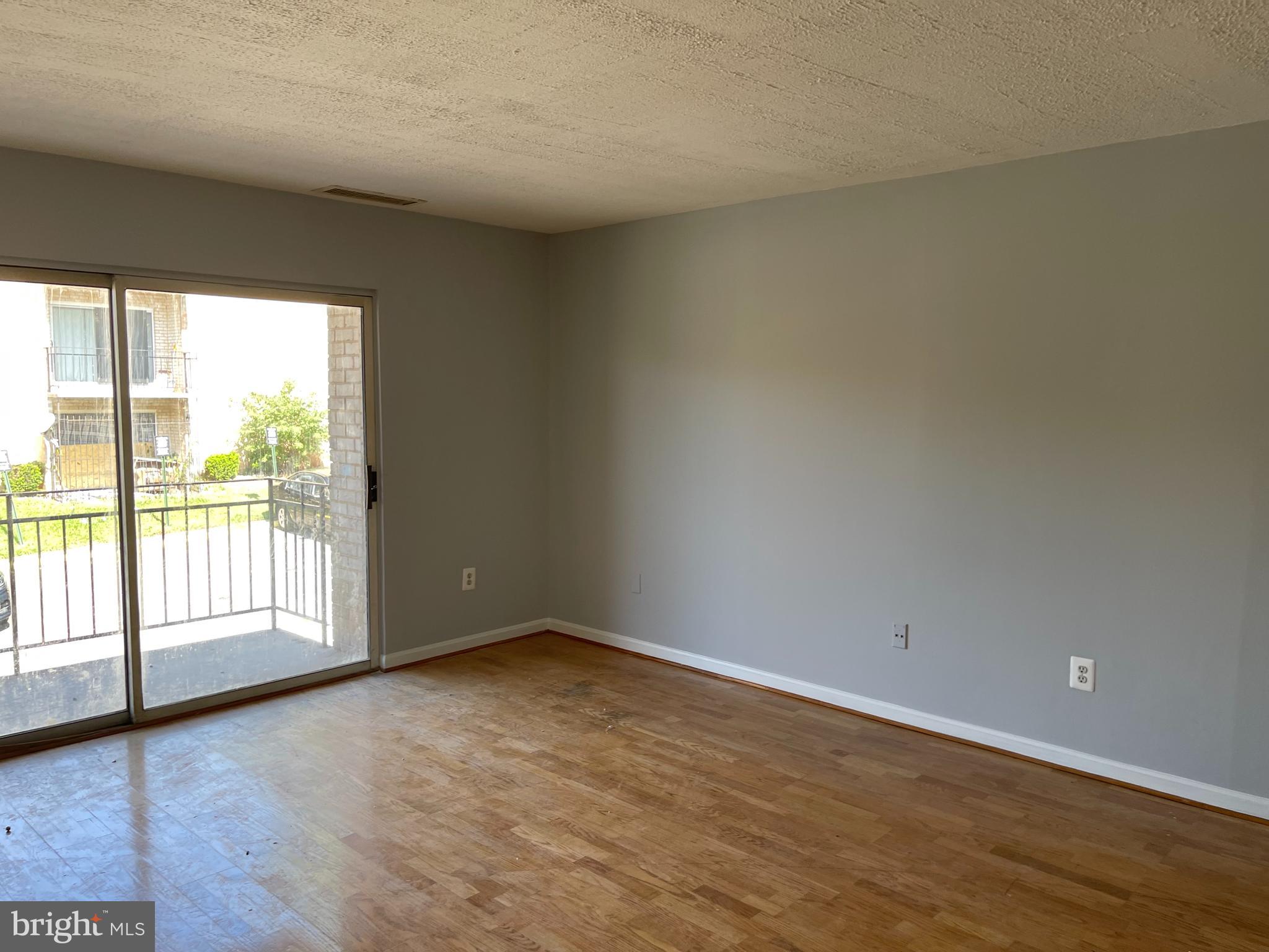 5106 F Street Southeast, Unit 8 Washington, DC 20019 - Photo 15 of 39 a view of an empty room with wooden floor and a window