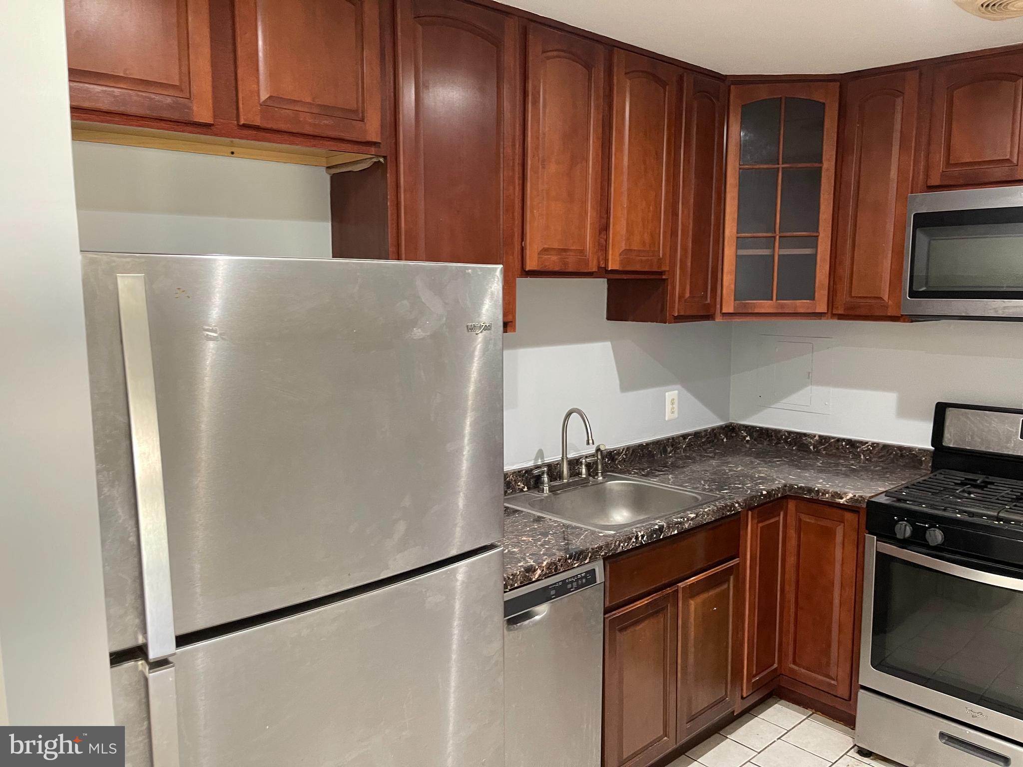 5106 F Street Southeast, Unit 8 Washington, DC 20019 - Photo 4 of 39 a kitchen with stainless steel appliances granite countertop a refrigerator sink and stove