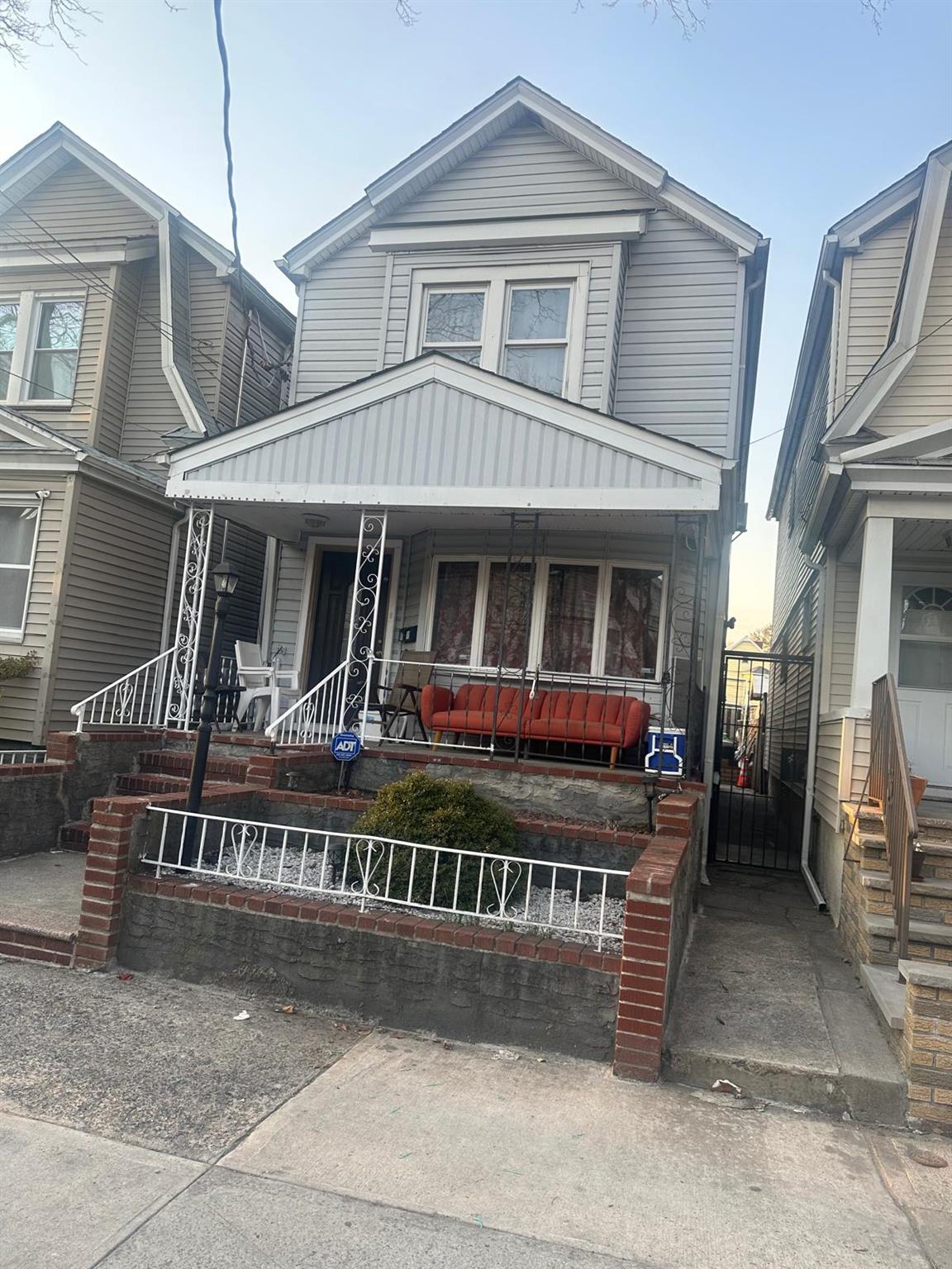a view of a white house with large windows and a small yard