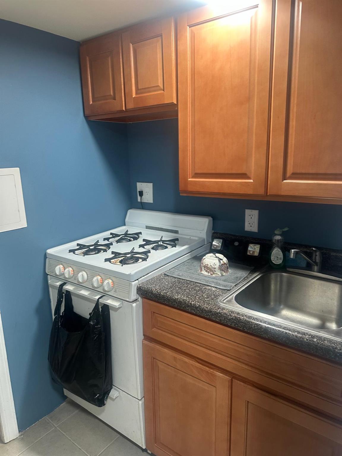 81-11 91st Avenue Queens, NY 11421 - Photo 11 of 15 a kitchen with granite countertop a sink a stove and cabinets