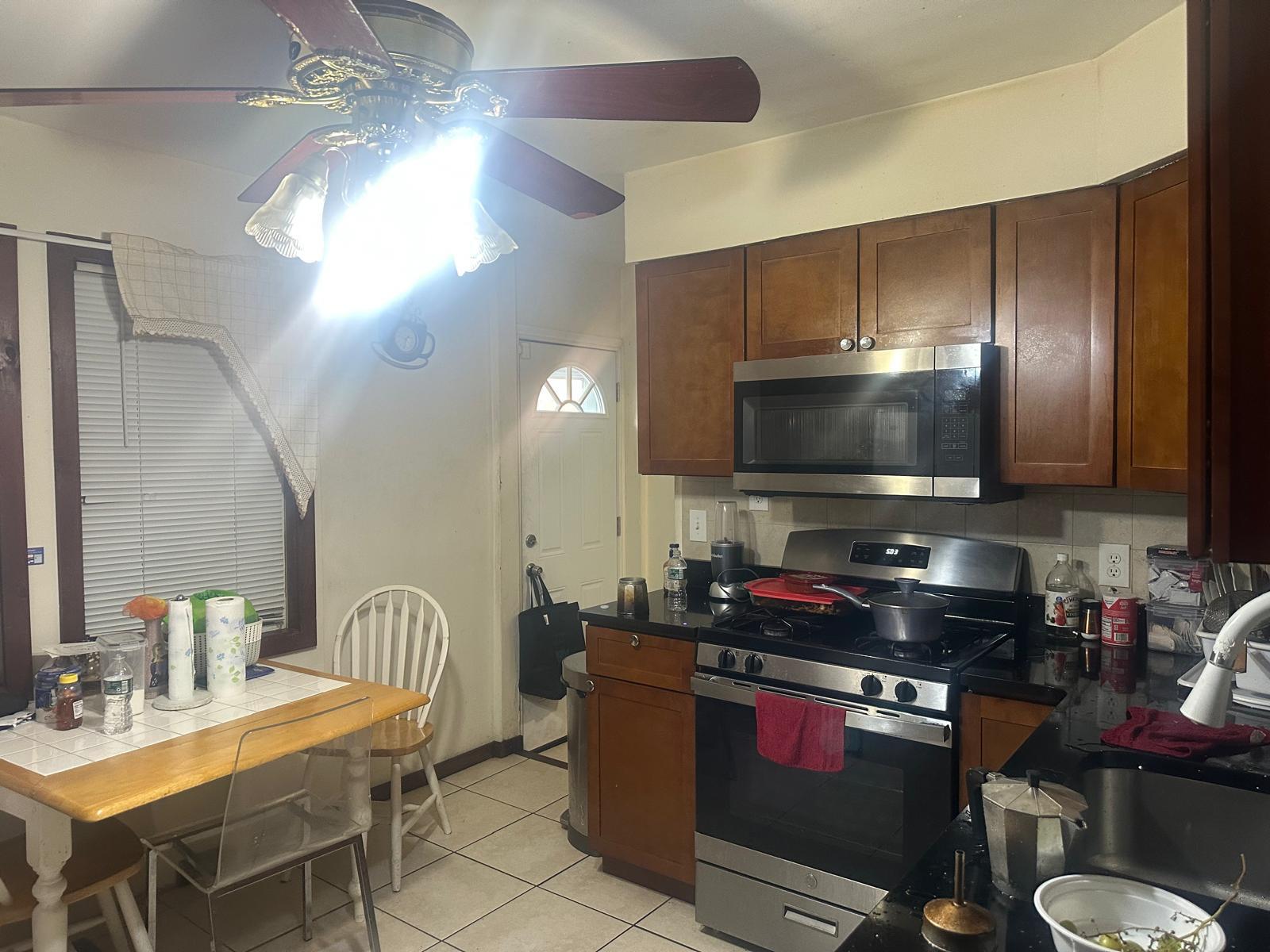 81-11 91st Avenue Queens, NY 11421 - Photo 3 of 15 a kitchen with a stove a sink and a microwave